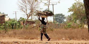 A woman with a baby carrying firewood in Kabile, Ghana. 
