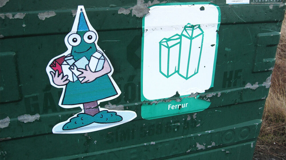 Side of recycling bin with cartoonish stickers