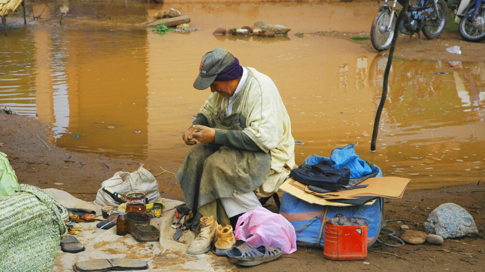 Person sits working on a task surrounded by objects