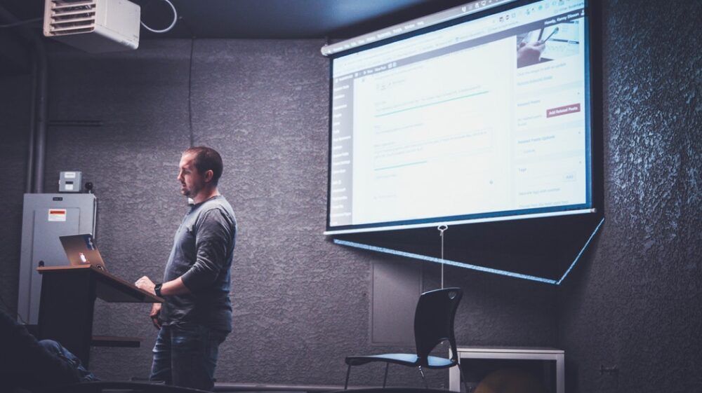 Seminar; person talking and showing infographics