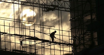 A construction worker amongst scaffolding.