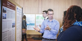 Researcher explaining findings seen on poster