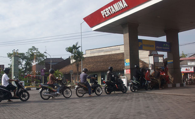 Motorcyclists queue up at a petrol station