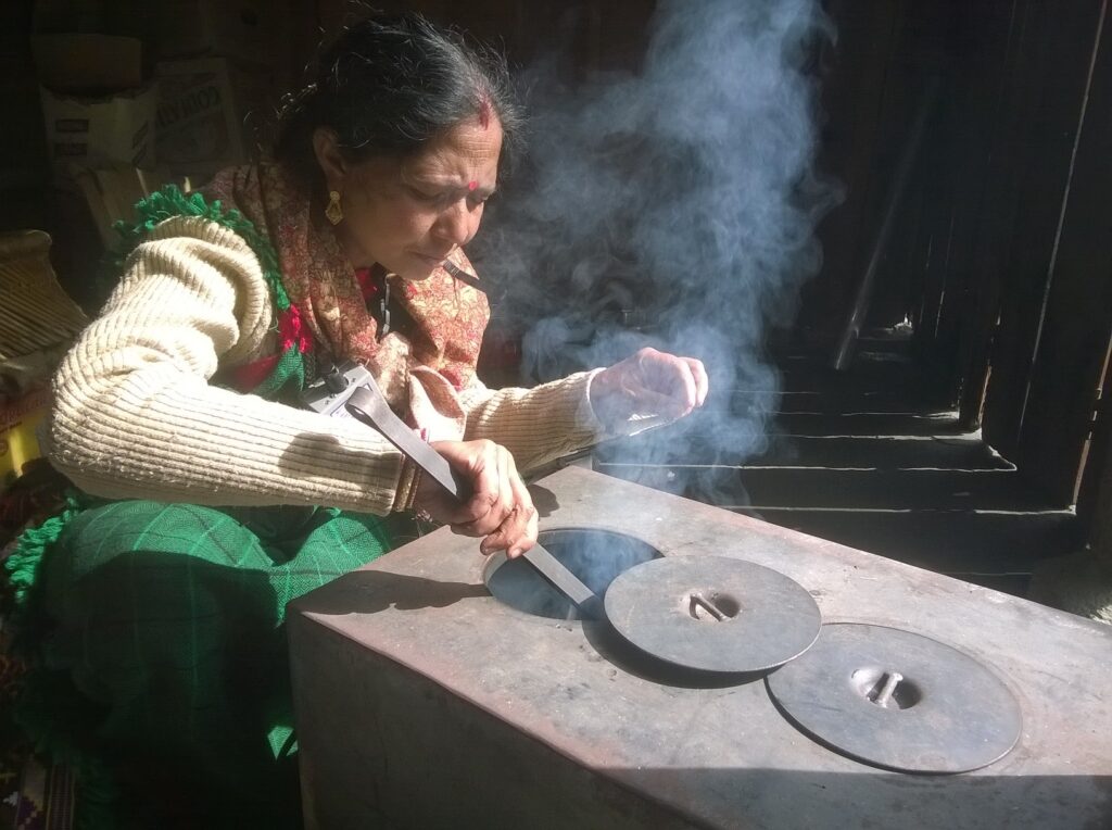 A woman cooking on an enclosed stove