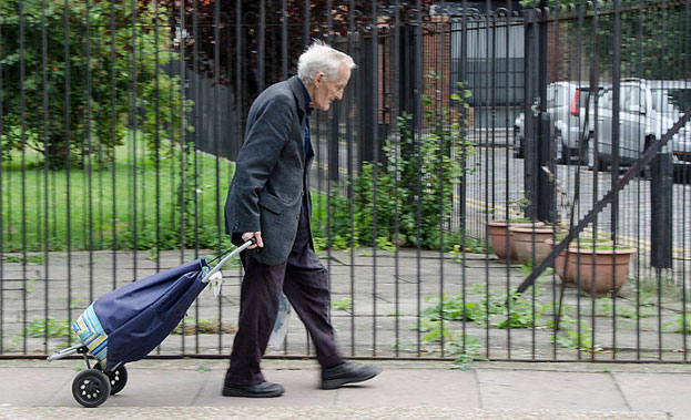 An elderly man walking down a street