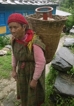 A woman carrying an LPG cylinder in a basket on her back