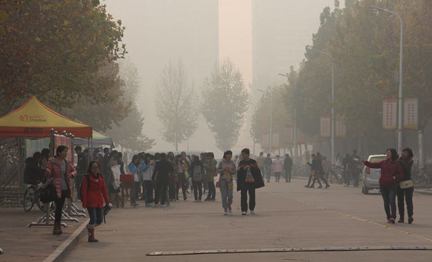 People walking in a street thick with smog