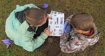 Worm-spotting for beginners: a young citizen scientist being shown how to identify earthworms as part of an OPAL survey.