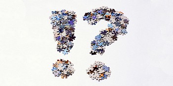 An exclamation and a question mark made of jigsaw puzzle pieces. These are mainly colored in shades of blue and brown with a gray cardboard back.