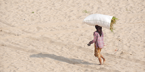 Woman carrying a bag on her head