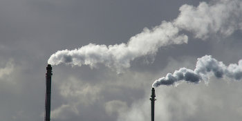 Two factory chimneys with smoke coming out of them