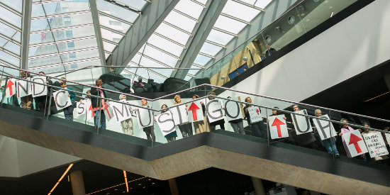 Members of civil society line the stairs calling for nationally determined contributions (NDCs) to go up, reminding delegates they must not 'back out' of their commitments.