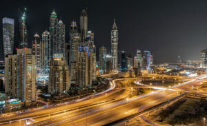 A bustling night view of Dubai's skyscrapers and roads
