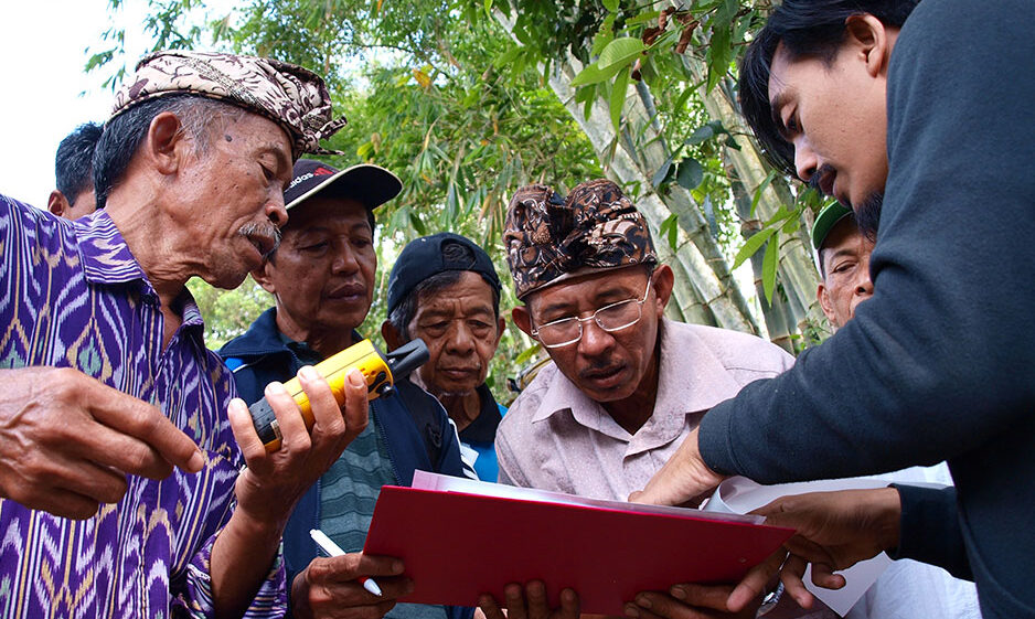 Farmers looking at information on a clipboard
