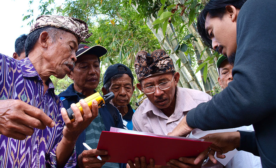 Farmers looking at information on a clipboard