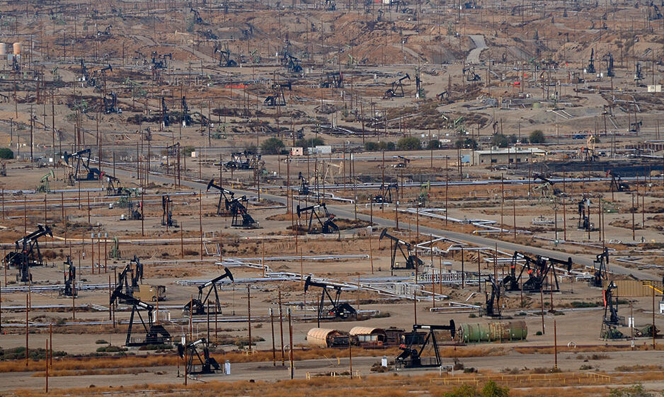 Oil derricks pump oil in a field in Bakersfield, California
