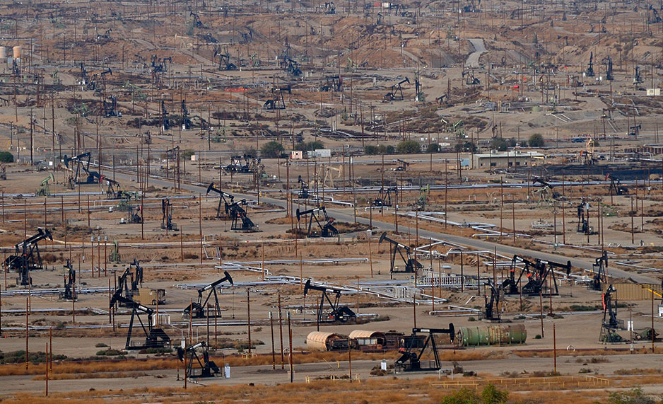 Oil derricks pump oil in a field in Bakersfield, California
