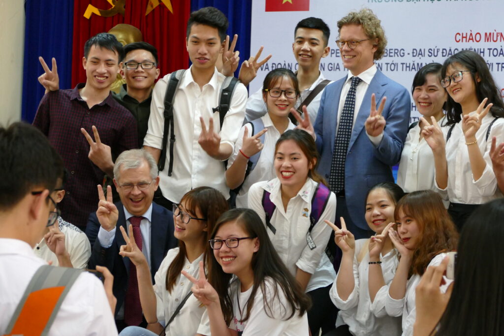 A group of students standing happily with Ambassador Högberg