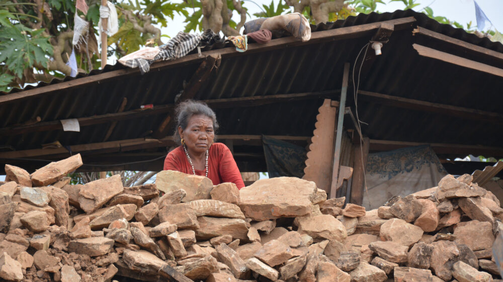 An unhappy woman near a pile of rubble