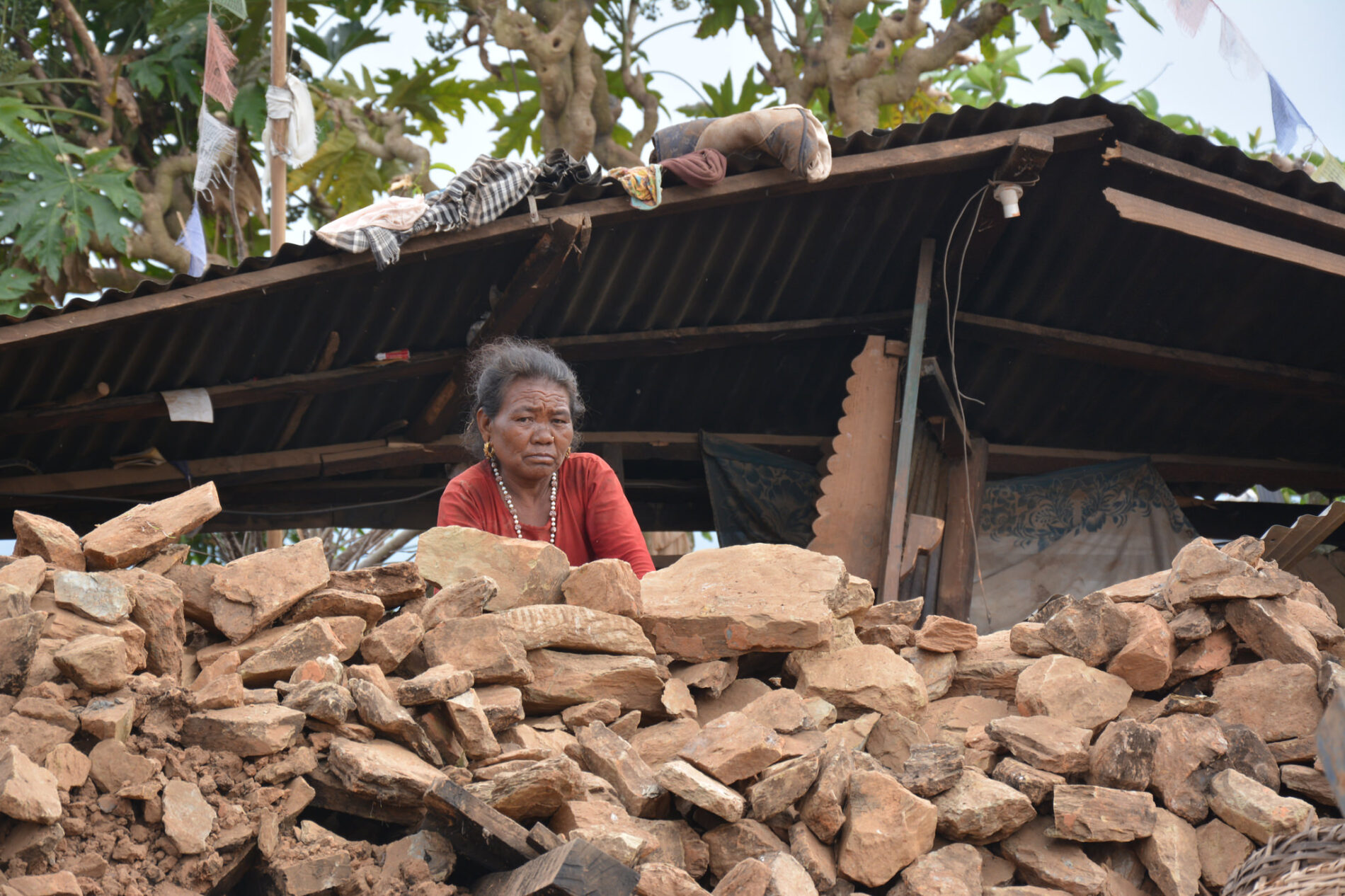 An unhappy woman near a pile of rubble