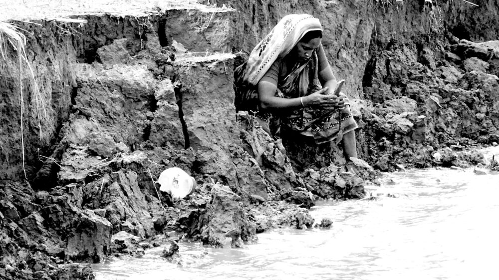 Photo of woman by eroded river bank in Bangladesh - Taneesha Mohan