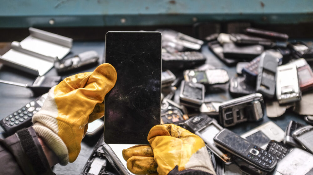 gloved hands holding old mobile phones