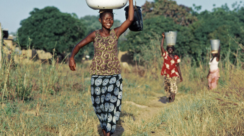 women walking through field