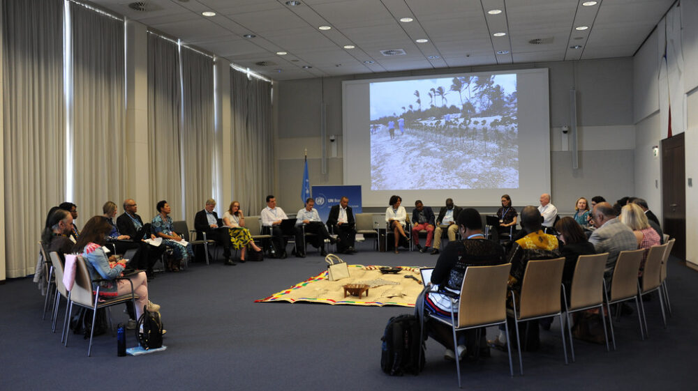 participants sitting in a conference room in a circle formation