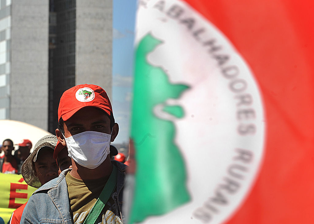 Photo - of a member of the Movement of Landless Rural Workers (MST), wearing a mask - Marcello Casal JR/ABr on Wikimedia CC3.