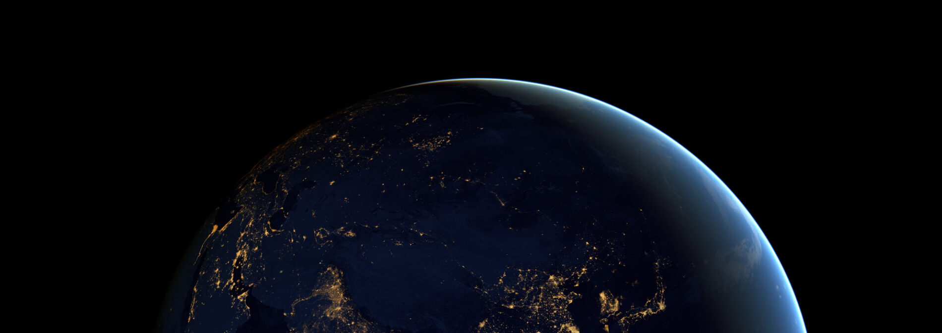 Photo of Earth as seen from space, with city lights illuminating an otherwise dark side of our planet.