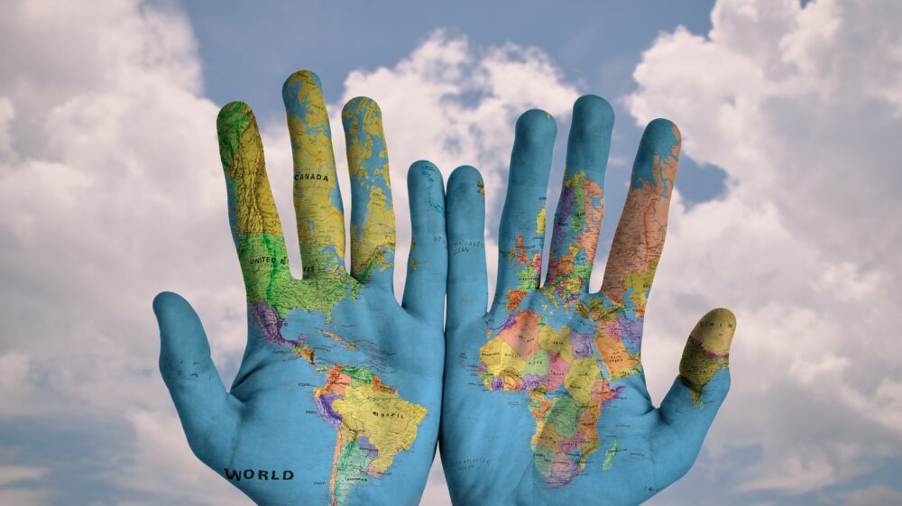 Map of the world traced onto a pair of hands.