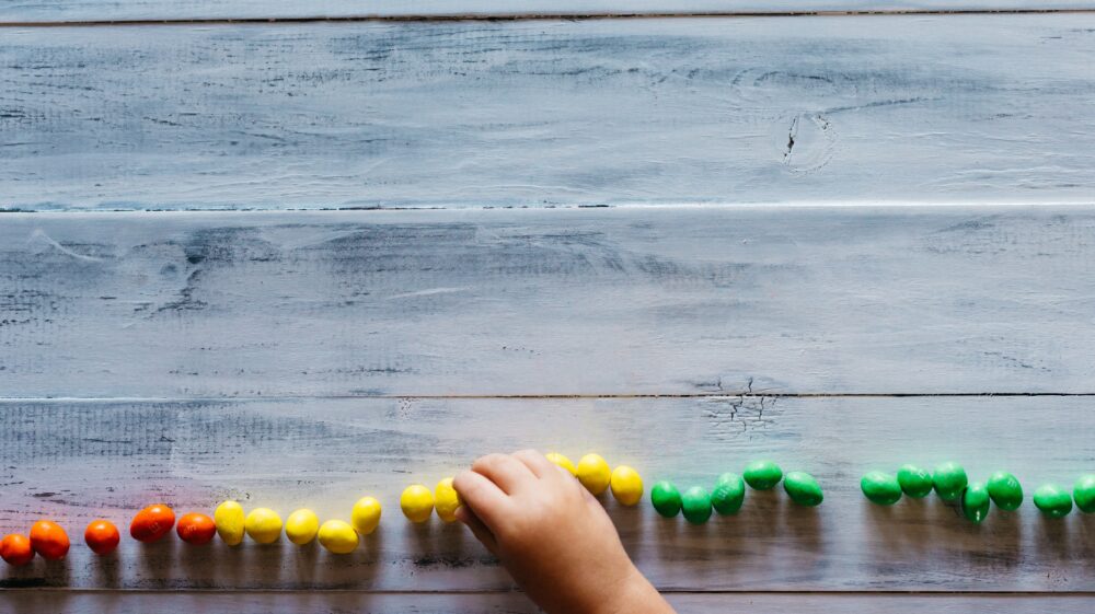 Child counting coloured candy