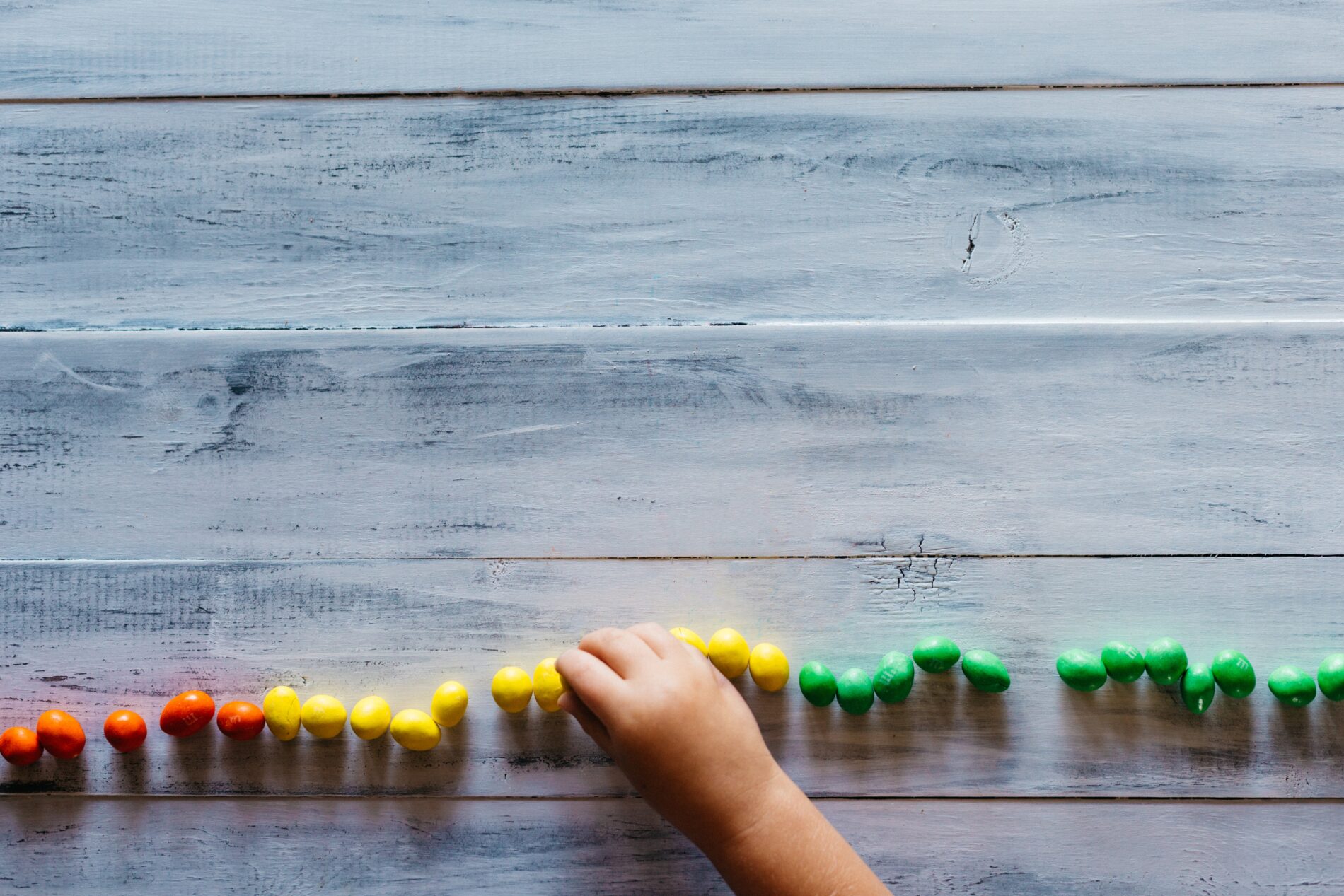 Child counting coloured candy