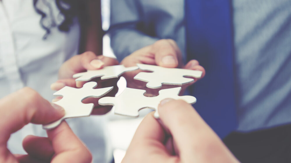 Group of business people holding a jigsaw puzzle pieces.