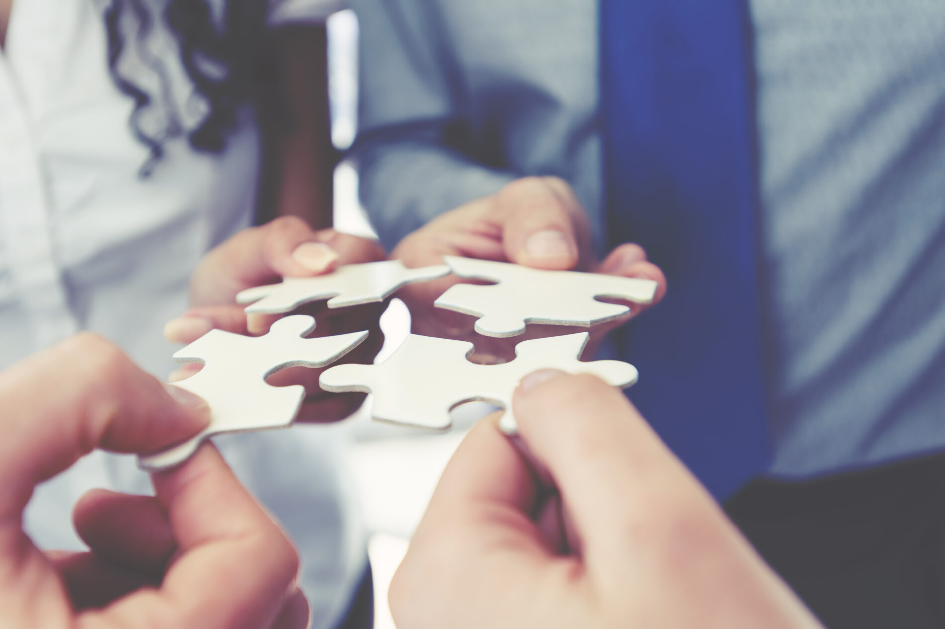 Group of business people holding a jigsaw puzzle pieces.