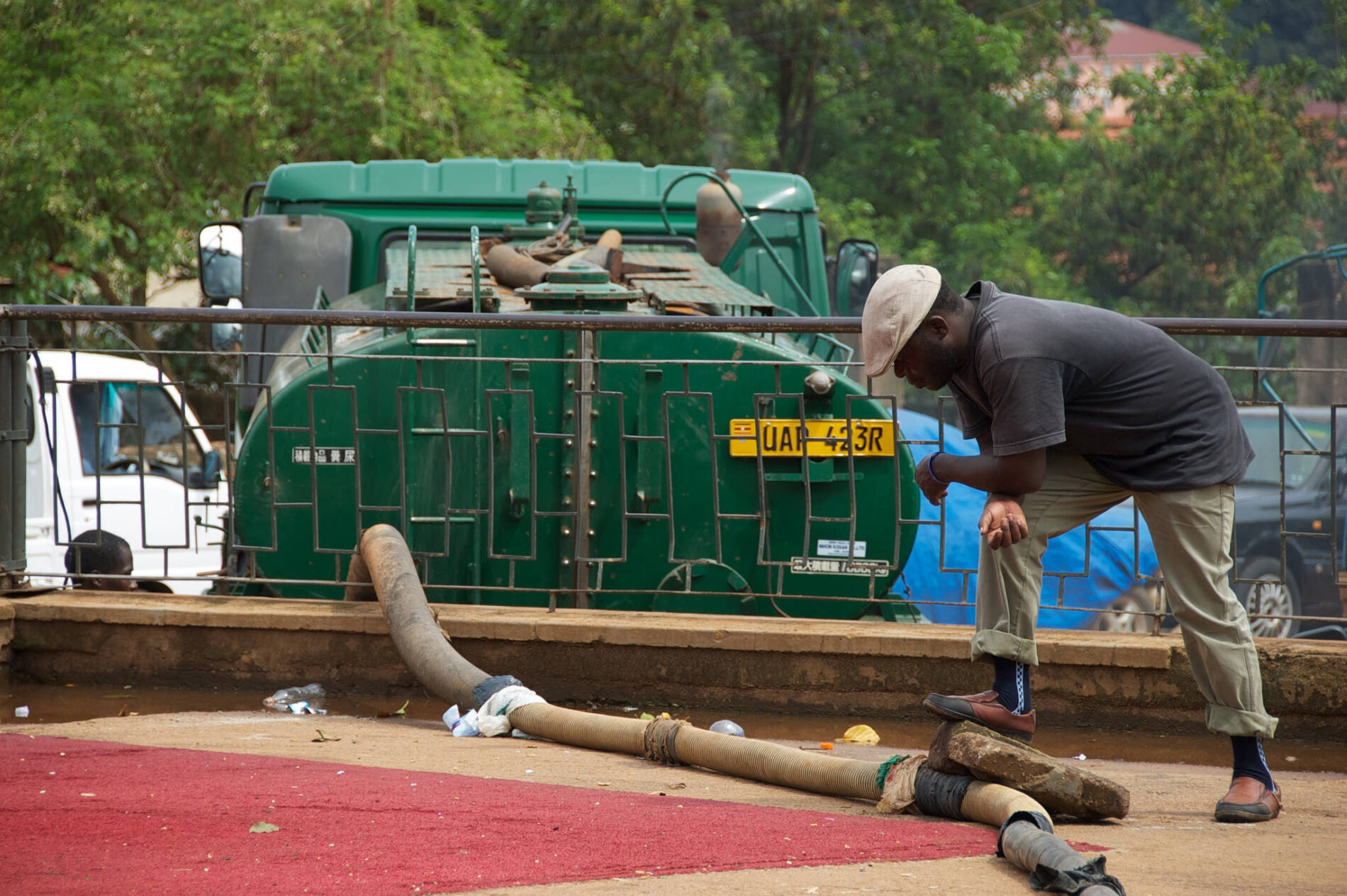 man attends to sewage collection truck and pipe