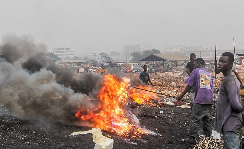 People burning cables in waste dump to collect copper, Ghana.