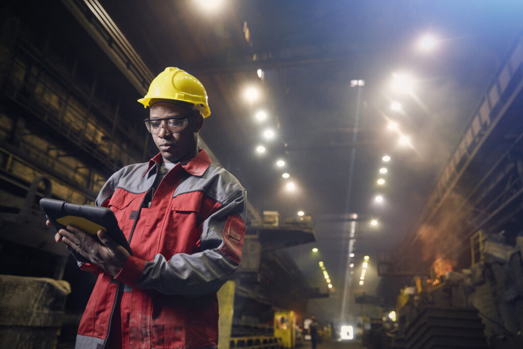 Steelworker using digital tablet in steel mill