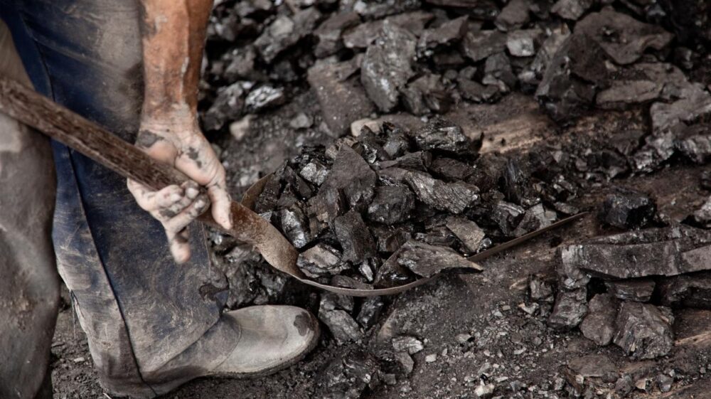 close up shot of miner shoveling coal