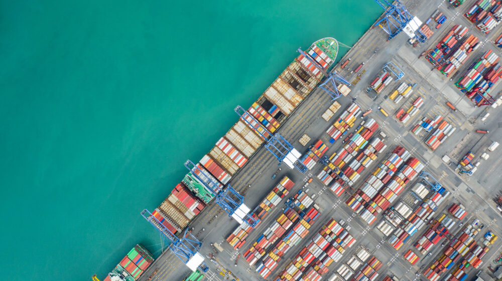 Aerial top view container cargo ship working. Business import export logistic and transportation of International by ship in the open sea.
