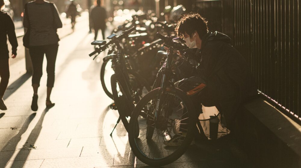 Man in black jacket In front of bicycle