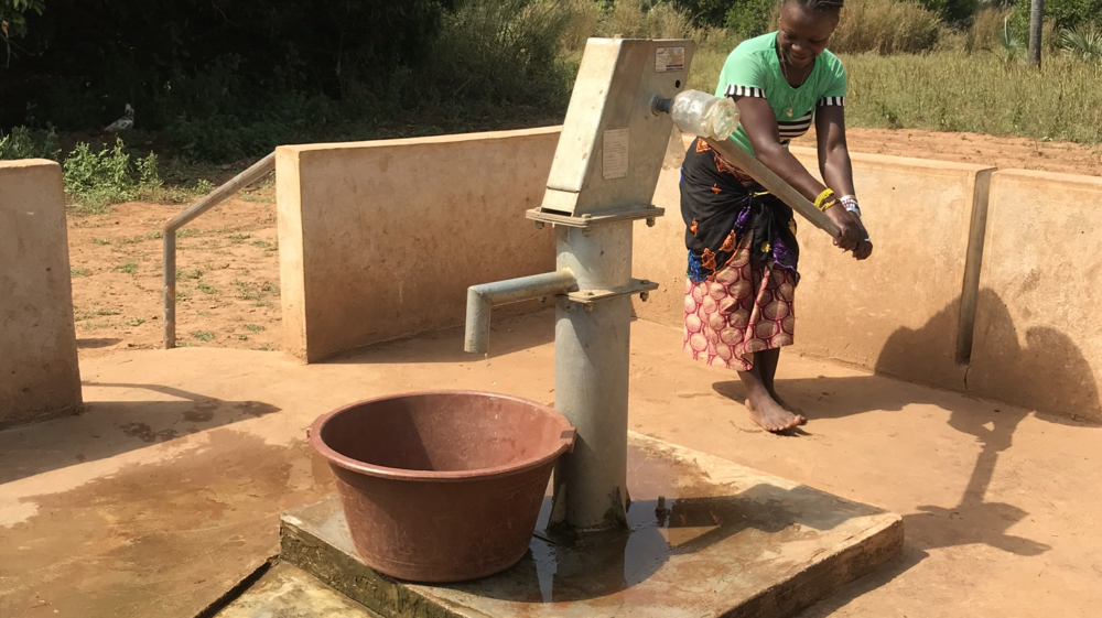 African woman pumping water