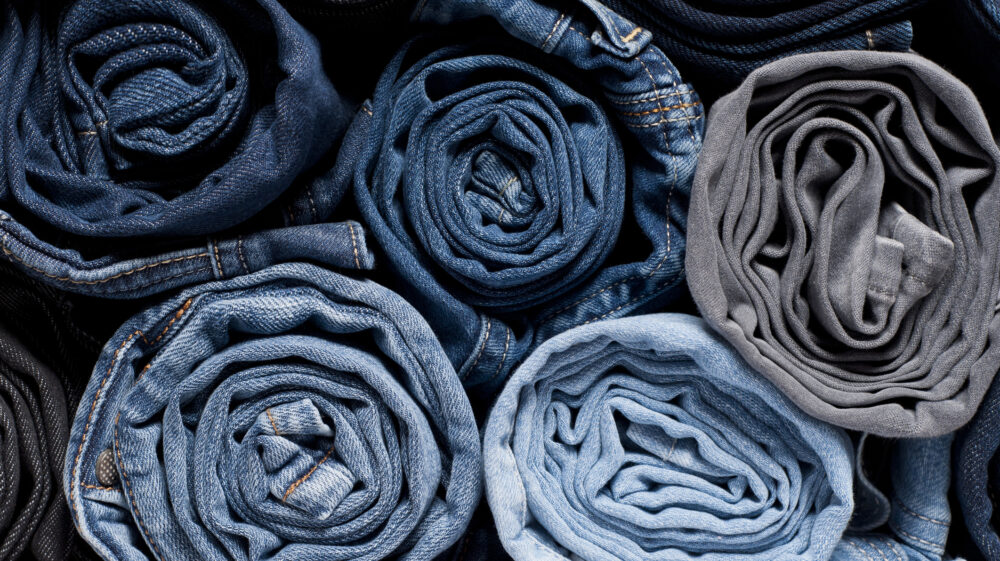 Stack of rolled jeans. Photo: Amete / Getty Images.