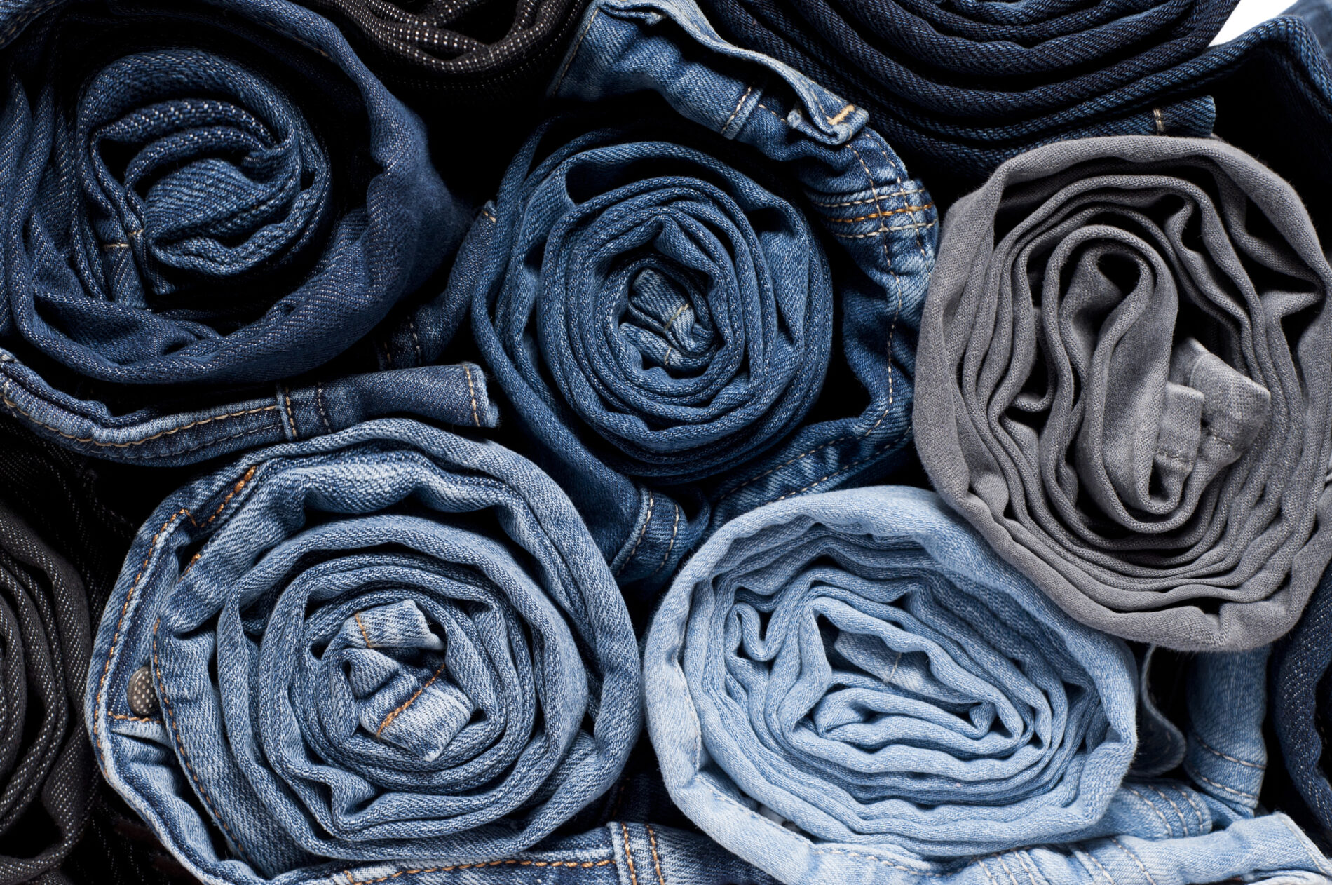 Stack of rolled jeans. Photo: Amete / Getty Images.
