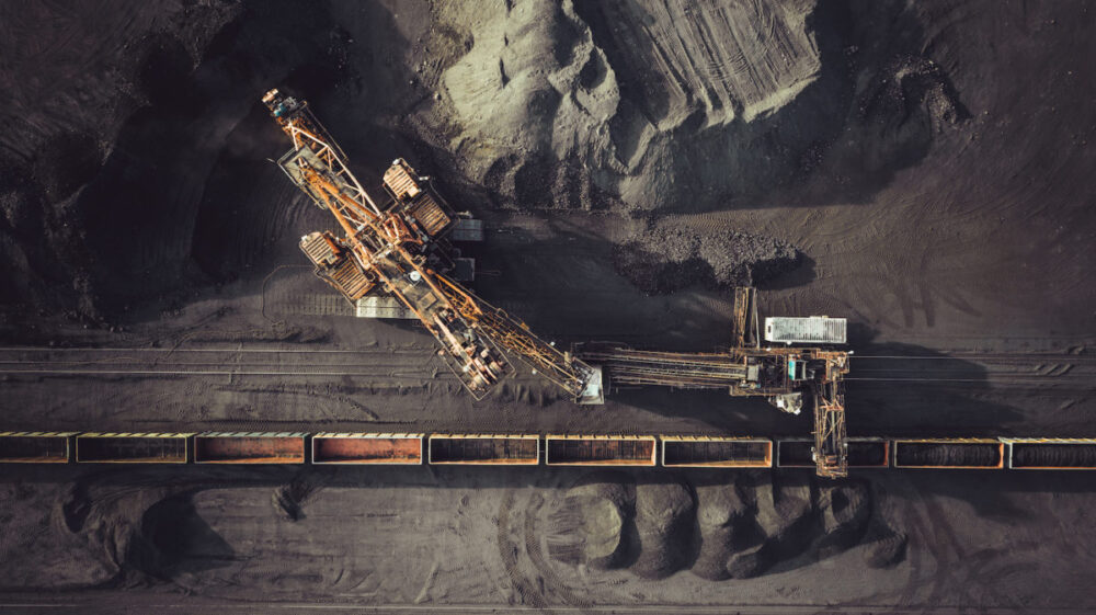 Coal mining. Aerial view. Excavator loading train cargos