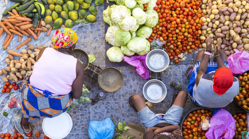 High angle view of vendors selling a selection of fresh vegetables on a street market.