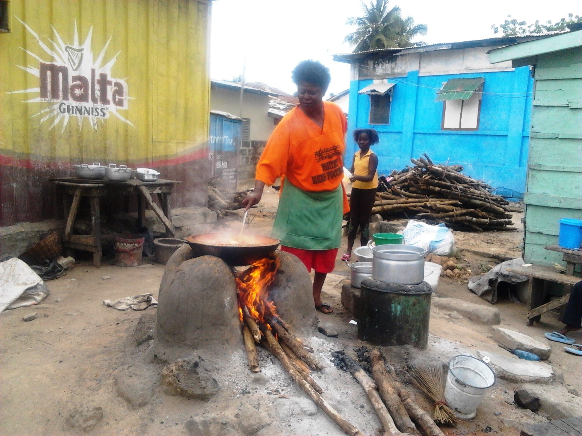 Woman cooking on a mud stove.