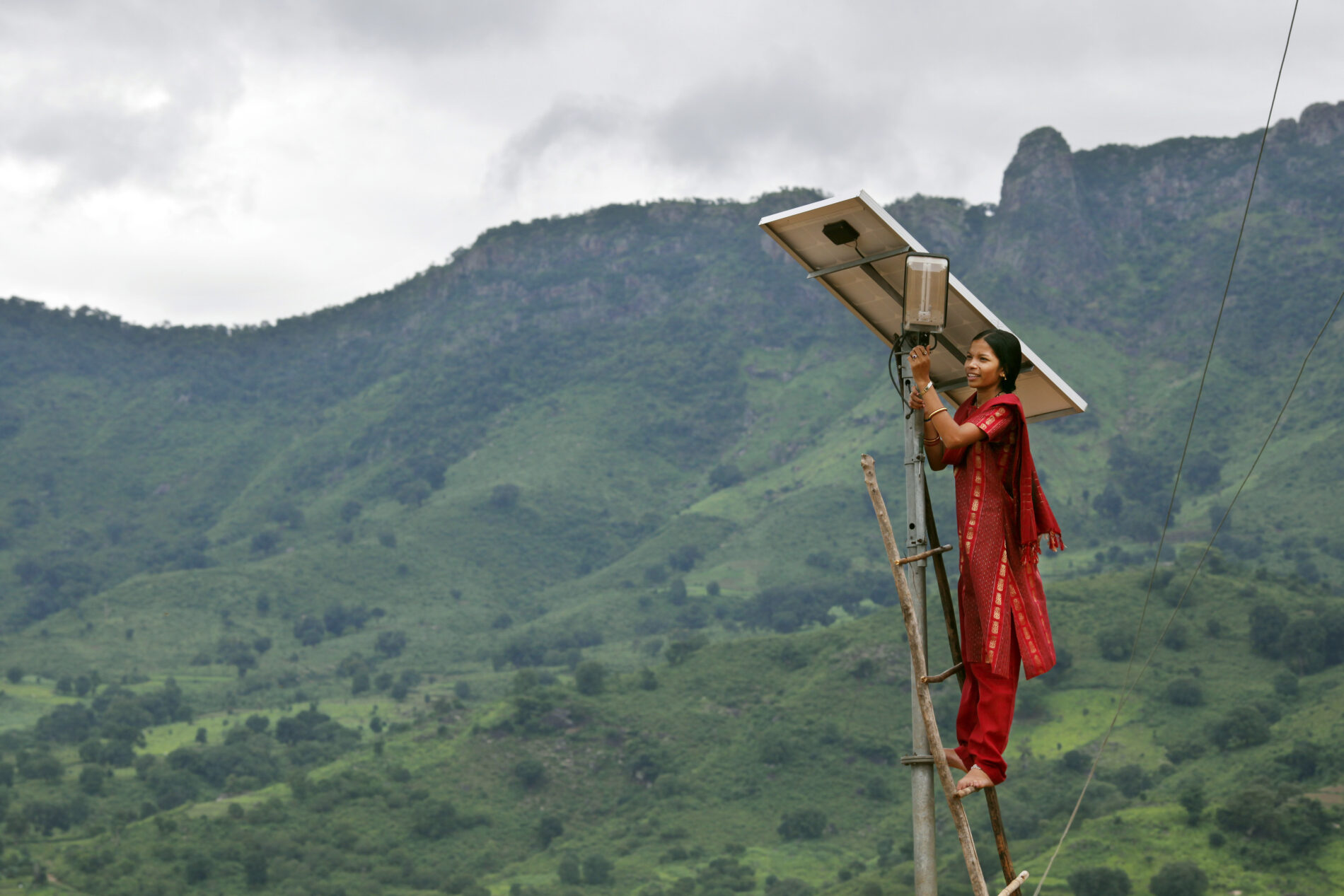 A solar engineer conducts maintenance on a solar panel in the solar-powered village of Tinginapu, India.