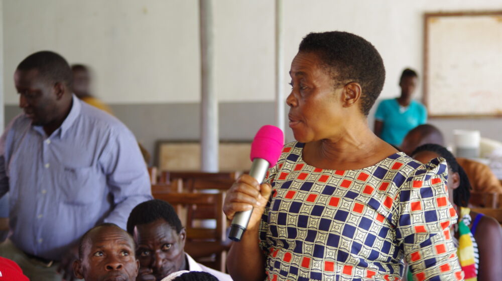 Woman dairy farmer speaking at a stakeholder meeting, Uganda, showing the importance of stakeholder engagement
