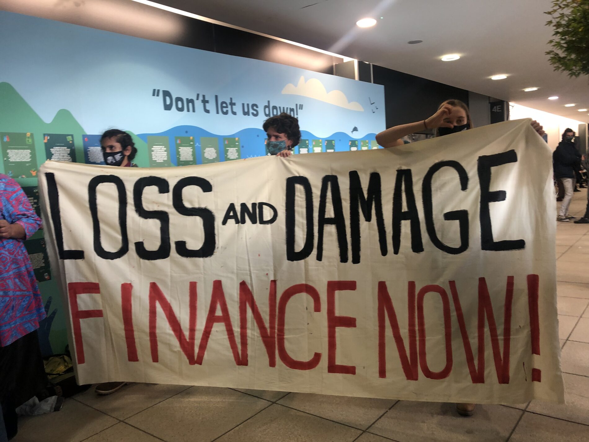 Protesters holding up banner saying Loss and damage